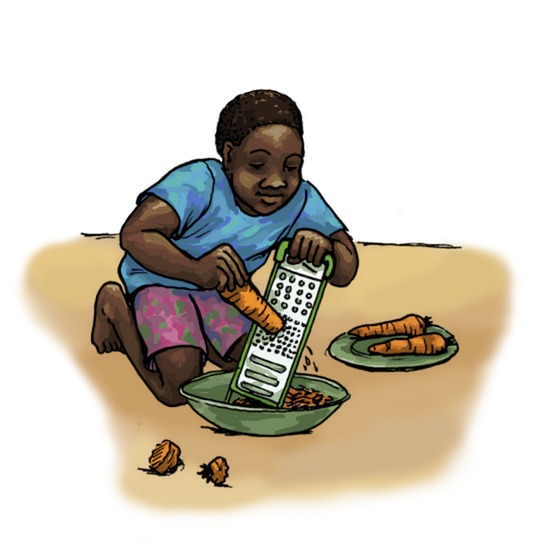 A boy grating carrots.