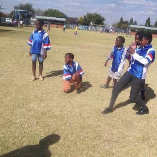 A girl and boys playing soccer.
