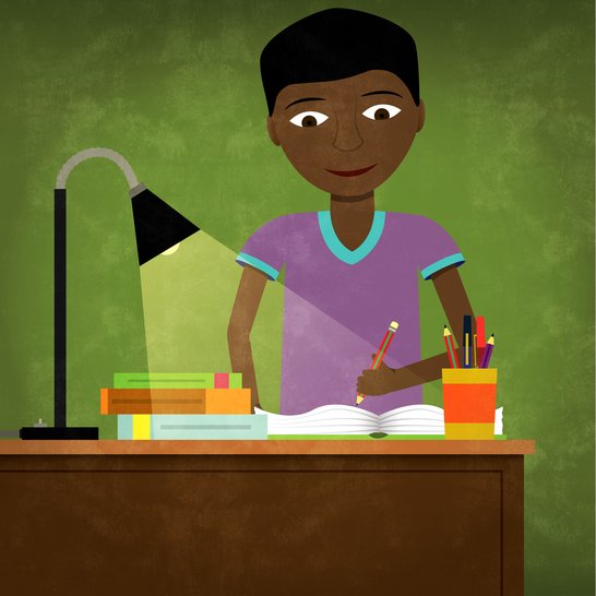 A boy sitting at a desk studying.